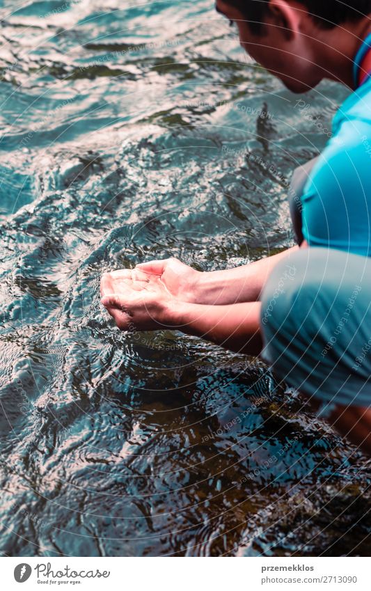 Kleiner Junge, der reines Wasser aus einem Fluss in den Händen nimmt. Körper Leben Mensch Mann Erwachsene Hand Umwelt Natur See Tropfen frisch nass natürlich