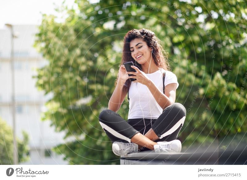 Afrikanische Frau beim Musikhören mit Kopfhörern und Smartphone Lifestyle Stil Glück schön Haare & Frisuren Sport Telefon PDA Technik & Technologie Mensch