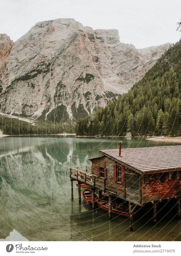 Holzhaus mit Booten zwischen den Bergen Dock Berge u. Gebirge See Anlegestelle Gelassenheit Haus Wald Wasserfahrzeug Baum Landschaft Reflexion & Spiegelung