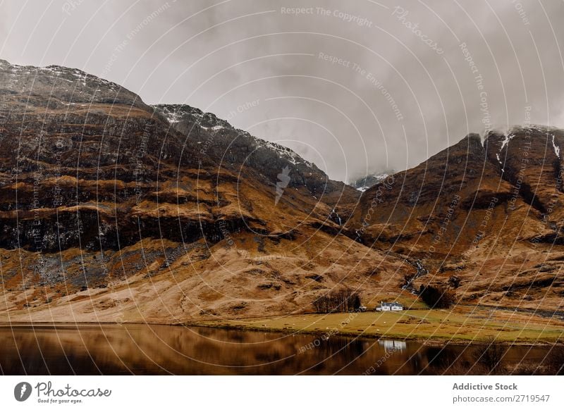 Kleines Haus am See und in den Bergen Küste Felsen Hügel Berge u. Gebirge weiß Schnee Landschaft Natur Wasser natürlich Stein schön Nebel Wolken Schottland Gras