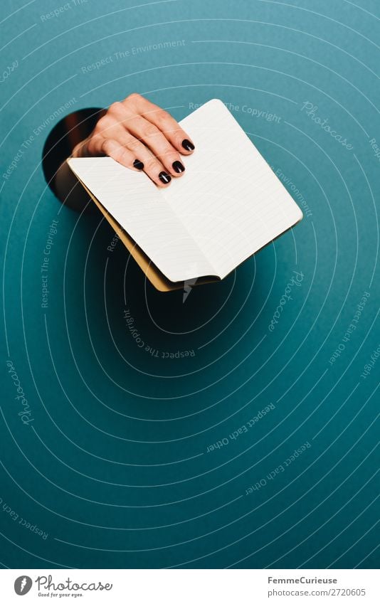 Hand of a woman holding a notebook in the camera feminin 1 Mensch Schreibwaren Papier Kommunizieren Notizbuch leer festhalten zeigen haltend türkis Kreis