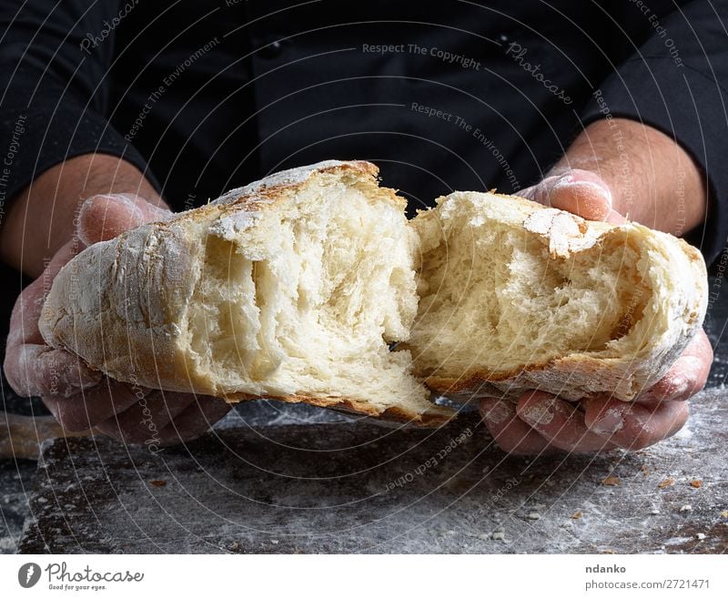 frisch gebackenes Weißweizenmehlbrot Teigwaren Backwaren Brot Ernährung Tisch Küche Mensch Hand Finger Holz machen dunkel braun schwarz weiß Tradition Bäcker