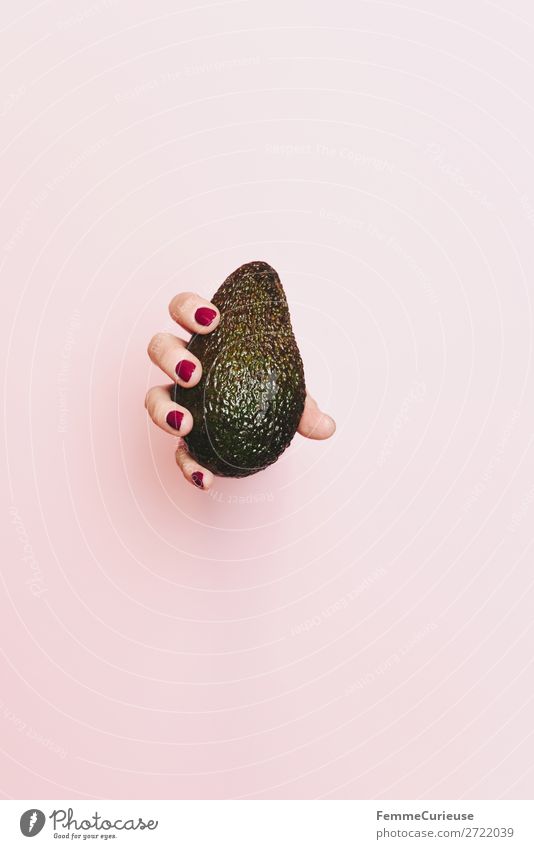 Hand of a woman holding an avocado Lebensmittel Ernährung Frühstück Abendessen Picknick Bioprodukte Vegetarische Ernährung Diät Gesundheit Gesunde Ernährung