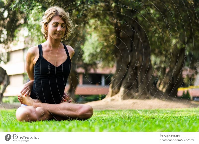 Frau, die Yoga praktiziert, die Locked Lotus Pose Baddha Padmasana. Diät Lifestyle schön Körper Erholung Meditation Freizeit & Hobby Sport Erwachsene Park