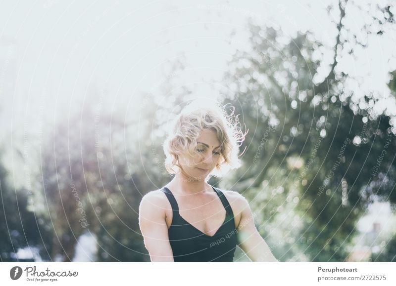 Frau meditiert und praktiziert Yoga, Lotus-Pose, Padmasana. Meditation an einem sonnigen Herbsttag im Park. Workout im Freien. Lifestyle schön Körper Wellness