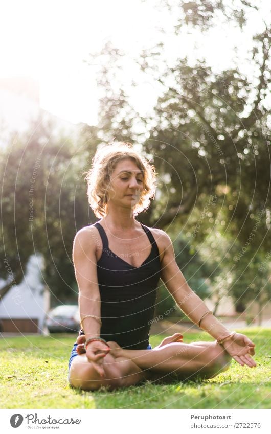 Meditierende und praktizierende Frau Yoga, Padmasana. Lifestyle schön Körper Wellness Leben harmonisch Erholung Meditation Erwachsene Natur Park Fitness sitzen