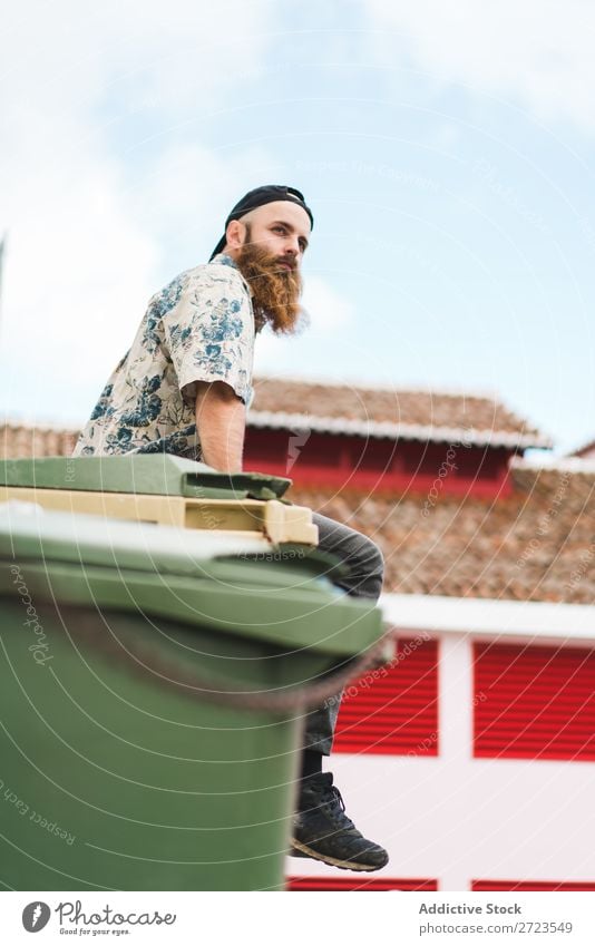 Bartiger Mann auf Müllcontainer sitzend Großstadt Straße bärtig Müllbehälter Container Lifestyle Jugendliche Stadt Mensch Typ Coolness Stil Erwachsene