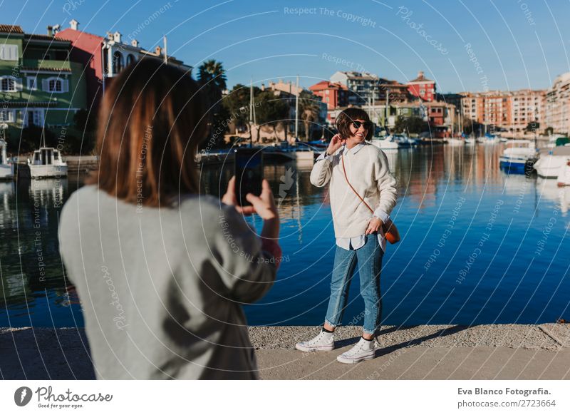 zwei Freunde auf der Straße, die mit dem Handy Fotos machen. Lifestyle Freude Glück schön Schminke Sonne Technik & Technologie Frau Erwachsene Freundschaft