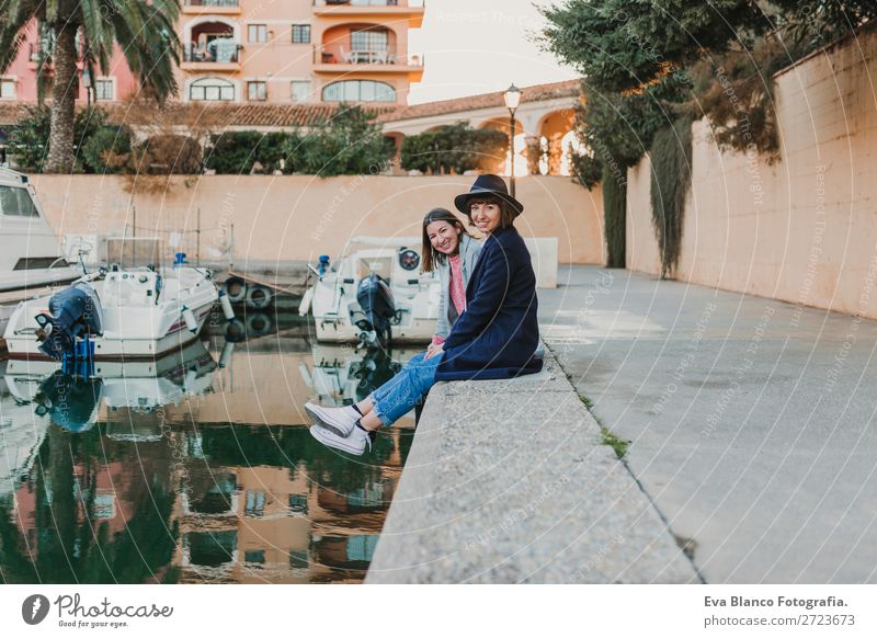 Zwei glückliche Freunde sitzen auf dem Dock am Hafen. Lifestyle Freude Glück Leben Sonne Haus Sitzung sprechen Frau Erwachsene Familie & Verwandtschaft