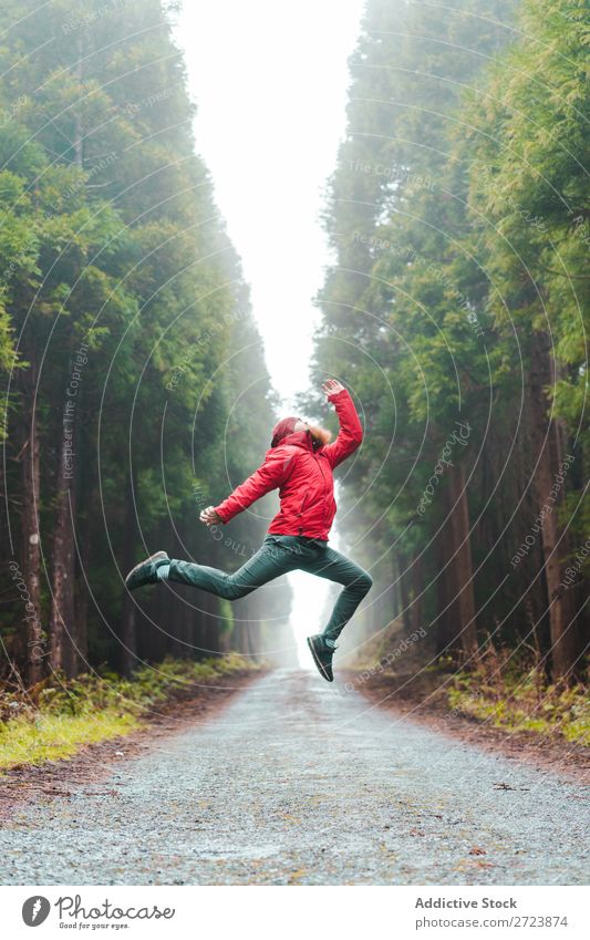 Mann, der auf der Straße im Wald springt. Tourist Natur bärtig springen rot Jacke Wege & Pfade grün Ferien & Urlaub & Reisen Abenteuer Landschaft Azoren wandern