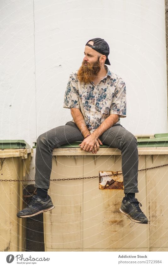 Bartiger Mann auf Müllcontainer sitzend Großstadt Straße bärtig Müllbehälter Container Lifestyle Jugendliche Stadt Mensch Typ Coolness Stil Erwachsene