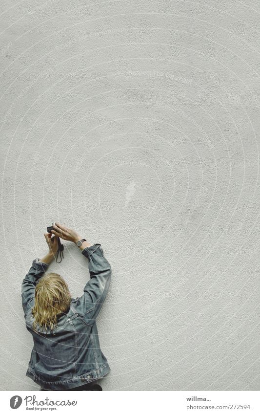 Blonde Frau in Jeansjacke fotografiert eine Wand Fotografieren Freizeit & Hobby Fotokamera Junge Frau Jugendliche Erwachsene Mensch Regen Fassade Jacke blond