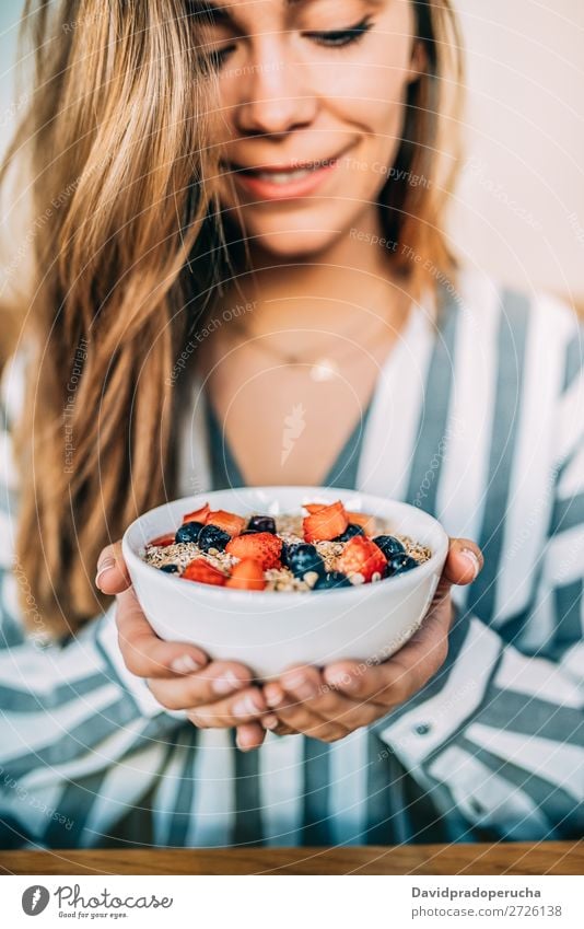 Frau aus der Nähe beim Essen von Hafer und Früchten Schüssel zum Frühstück Schalen & Schüsseln Müsli Haferbrei Hand Feldfrüchte Erdbeeren Blaubeeren Gesundheit