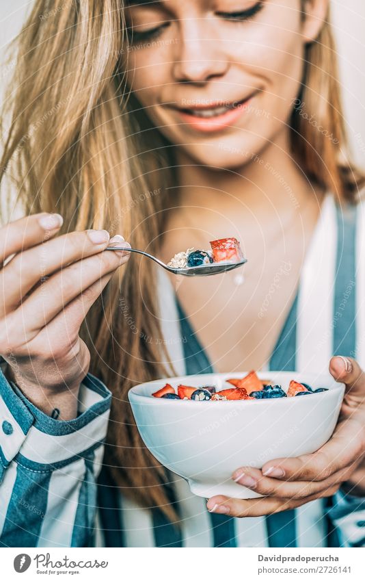 Frau aus der Nähe beim Essen von Hafer und Früchten Schüssel zum Frühstück Schalen & Schüsseln Müsli Haferbrei Hand Feldfrüchte Erdbeeren Blaubeeren Gesundheit