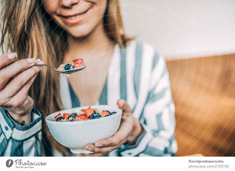 Getreidefrau aus der Nähe beim Essen von Hafer und Früchten Schüssel zum Frühstück Schalen & Schüsseln Frau Müsli Haferbrei Hand Feldfrüchte anonym unkenntlich