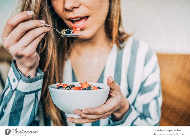 Getreidefrau aus der Nähe beim Essen von Hafer und Früchten Schüssel zum Frühstück Schalen & Schüsseln Frau Müsli Haferbrei Hand Feldfrüchte anonym unkenntlich