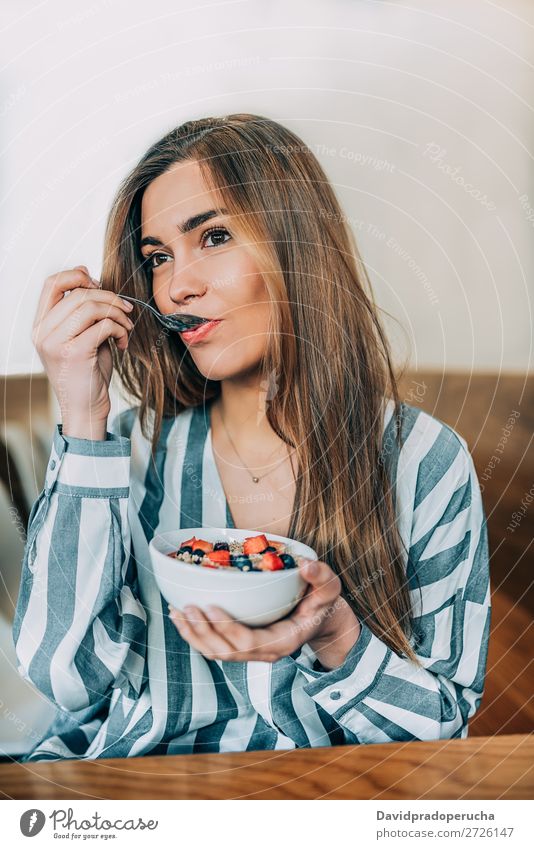 Frau aus der Nähe beim Essen von Hafer und Früchten Schüssel zum Frühstück Schalen & Schüsseln Müsli Haferbrei Hand Feldfrüchte Erdbeeren Blaubeeren Gesundheit