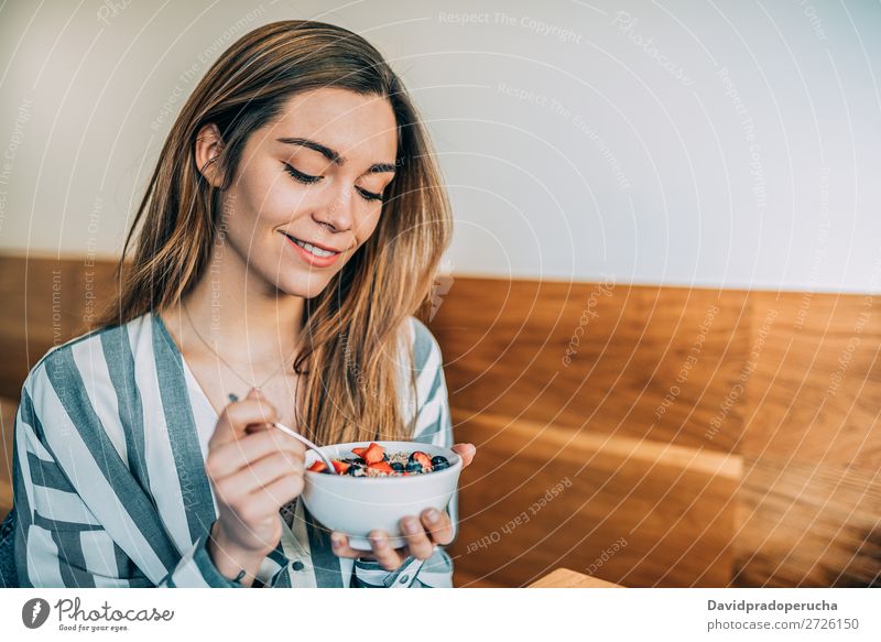 Frau aus der Nähe beim Essen von Hafer und Früchten Schüssel zum Frühstück Schalen & Schüsseln Müsli Haferbrei Hand Feldfrüchte Erdbeeren Blaubeeren Gesundheit