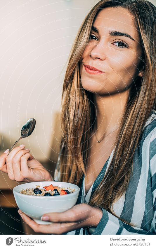 Frau aus der Nähe beim Essen von Hafer und Früchten Schüssel zum Frühstück Schalen & Schüsseln Müsli Haferbrei Hand Lächeln Feldfrüchte Erdbeeren Blaubeeren