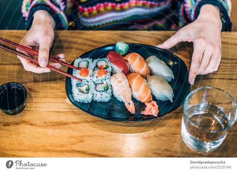 Getreidefrau beim Sushi essen Frau Vogelperspektive Hand Lebensmittel Soja maki Kalifornische Walze Essstäbchen Brötchen Feldfrüchte unkenntlich anonym