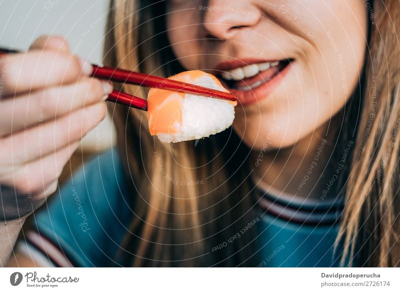 Getreidefrau beim Sushi essen Frau Lächeln Hand Lebensmittel Soja maki Kalifornische Walze Essstäbchen Brötchen Feldfrüchte unkenntlich anonym Nahaufnahme