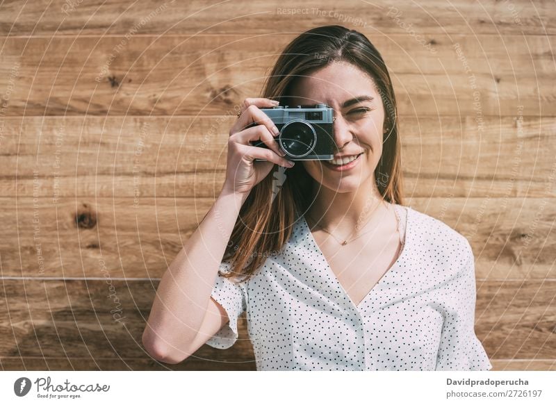 Schöne Frau mit alter Kamera, die Fotos macht. altehrwürdig Fotokamera retro Jugendliche nehmen Schuss auf die Kamera schauen schön Rolle Porträt Fotografie