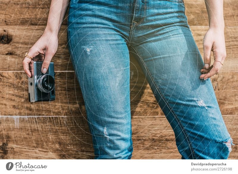 Beschnittene Frau Jeansbeine mit alter alter Kamera altehrwürdig Fotokamera retro Beine Jugendliche Anschnitt Rolle anonym unkenntlich Porträt Fotografie