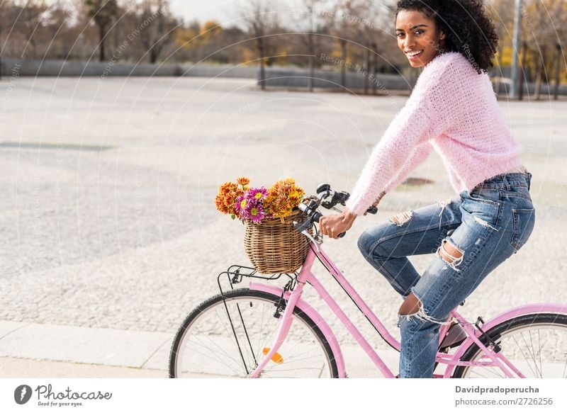 Schwarze junge Frau auf einem Oldtimer-Fahrrad Mädchen altehrwürdig Ausritt schön retro Blume Glück Blumenstrauß Sommer Jugendliche hübsch Frühling Korb