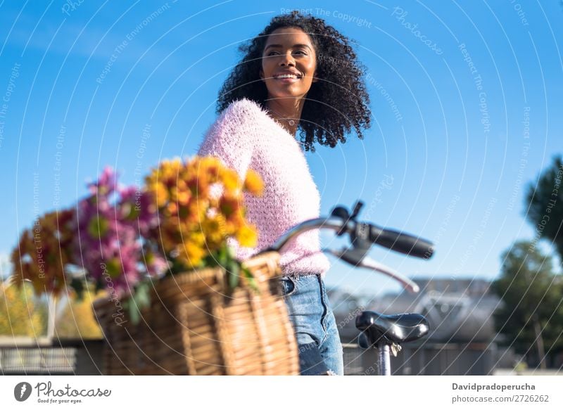 Schwarze junge Frau auf einem Oldtimer-Fahrrad Mädchen altehrwürdig Ausritt schön retro Blume Sonnenstrahlen Glück Blumenstrauß Sommer Jugendliche hübsch