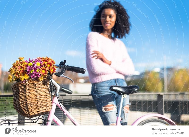 Schwarze junge Frau auf einem Oldtimer-Fahrrad Mädchen altehrwürdig Ausritt schön retro Blume Sonnenstrahlen Glück Blumenstrauß Sommer Jugendliche hübsch