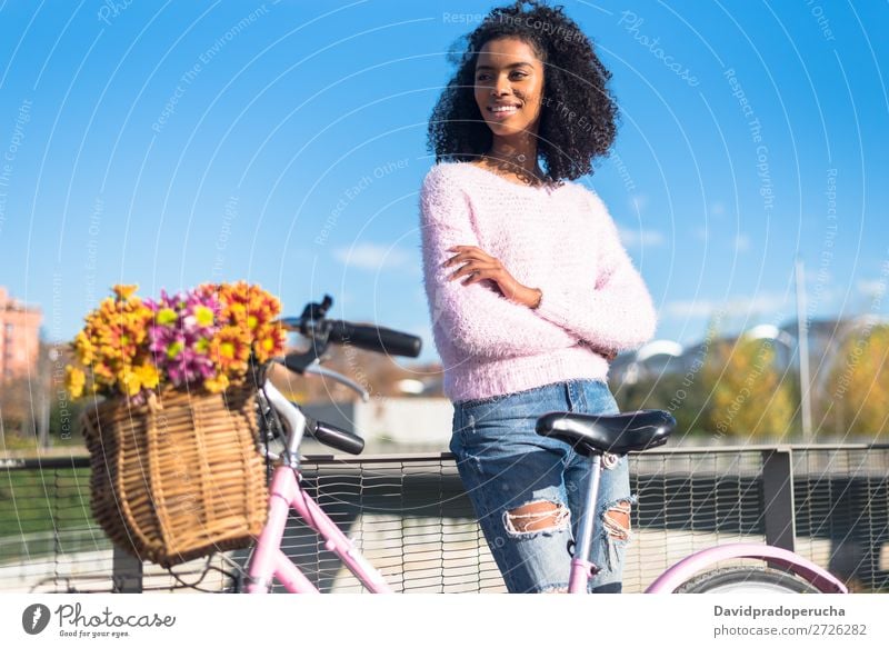 Schwarze junge Frau auf einem Oldtimer-Fahrrad Mädchen altehrwürdig Ausritt schön retro Blume Sonnenstrahlen Glück Blumenstrauß Sommer Jugendliche hübsch