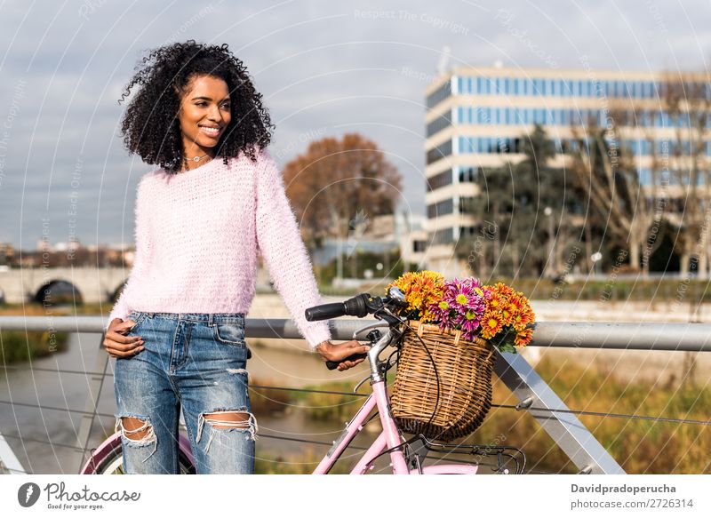 Schwarze junge Frau auf einem Oldtimer-Fahrrad Mädchen altehrwürdig Ausritt schön retro Blume Sonnenstrahlen Glück Blumenstrauß Sommer Jugendliche hübsch