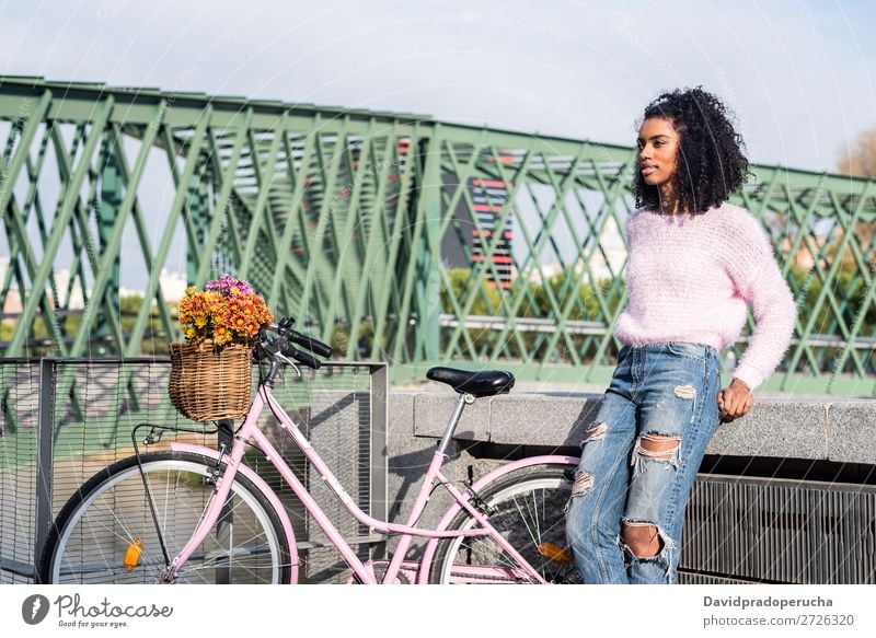 Schwarze junge Frau auf einem Oldtimer-Fahrrad Mädchen altehrwürdig Ausritt schön retro Blume Sonnenstrahlen Glück Blumenstrauß Sommer Jugendliche hübsch