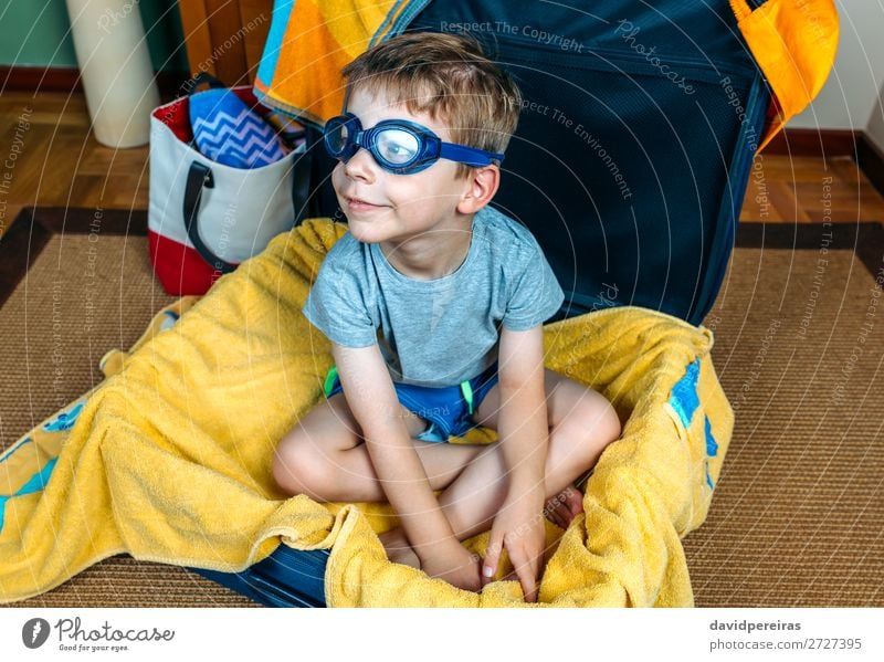 Lustiger Junge lächelnd in einem Koffer sitzend. Lifestyle Freude Schwimmbad Freizeit & Hobby Ferien & Urlaub & Reisen Ausflug Sommer Strand Kind Mensch Mann