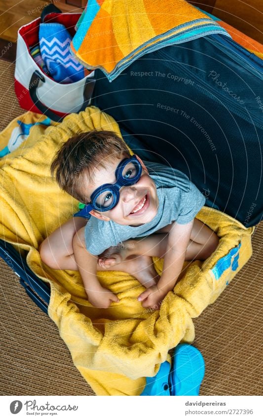 Lustiger Junge lächelnd in einem Koffer sitzend. Lifestyle Freude Glück Schwimmbad Freizeit & Hobby Ferien & Urlaub & Reisen Ausflug Sommer Strand Kind Mensch