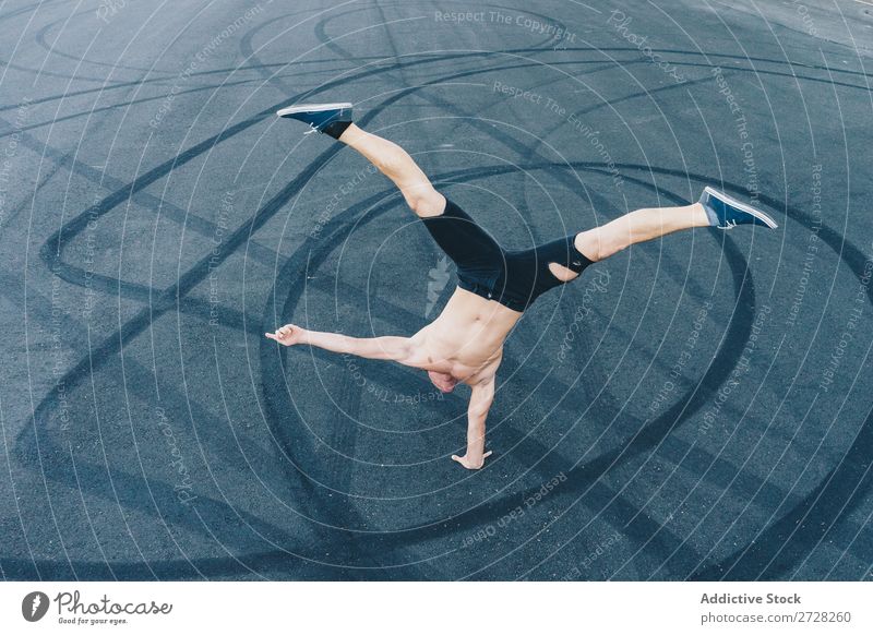 Anonymer Mann, der auf dem Bürgersteig tanzt. Tänzer Gleichgewicht Straßenbelag Handstand Breakdancer akrobatisch sportlich Sport Körperhaltung ohne Hemd Artist