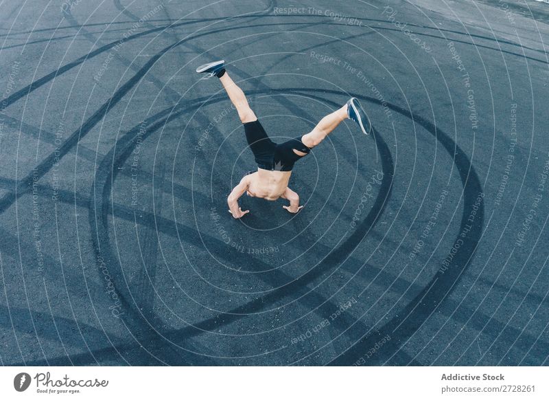 Anonymer Mann, der auf dem Bürgersteig tanzt. Tänzer Gleichgewicht Straßenbelag Handstand Breakdancer akrobatisch sportlich Sport Körperhaltung ohne Hemd Artist