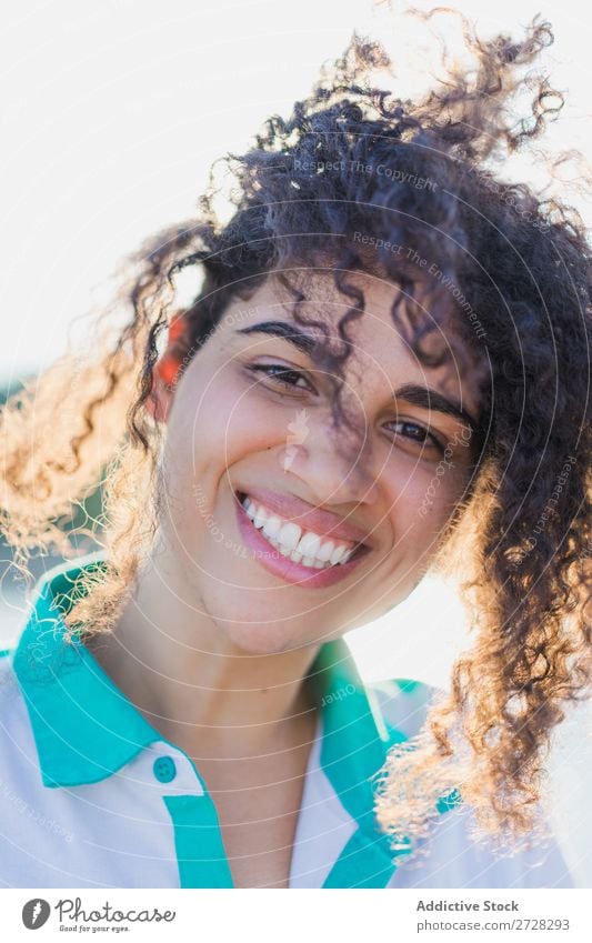 Lockenförmige Frau, die im Sonnenlicht auf der Natur posiert. Sommer genießen Körperhaltung Menschliches Gesicht Landschaft Farbe Porträt lockig ruhig