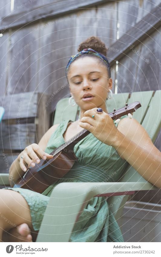 Mädchen spielt Ukulele im Gartenstuhl Frau Musiker Erholung Sommer Gitarre Instrument schön Jugendliche Künstler Lifestyle Freizeit & Hobby Musical Klang