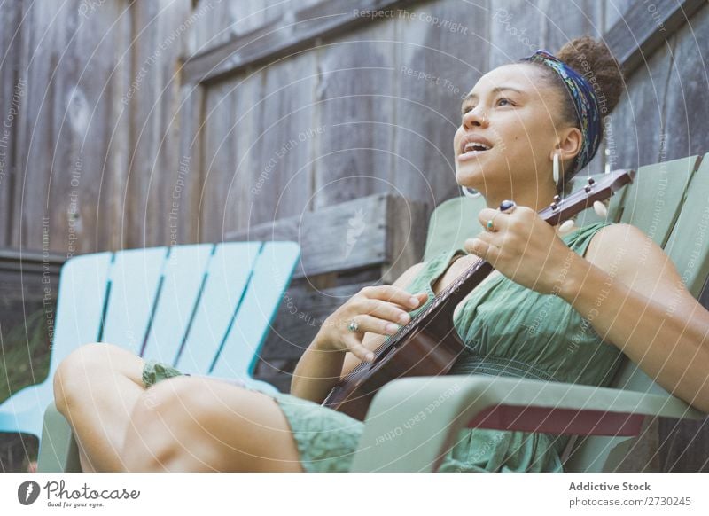 Mädchen spielt Ukulele im Gartenstuhl Frau Musiker Erholung Sommer Gitarre Instrument schön Jugendliche Künstler Lifestyle Freizeit & Hobby Musical Klang