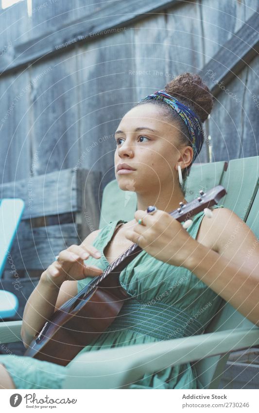 Mädchen spielt Ukulele im Gartenstuhl Frau Musiker Erholung Sommer Gitarre Instrument schön Jugendliche Künstler Lifestyle Freizeit & Hobby Musical Klang