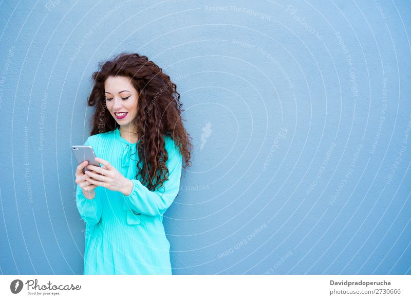 Glückliche junge Frau auf dem Handy an einer bunten Wand rothaarig Telefon Business Geschäftsfrau Technik & Technologie Mobile Lächeln Gesicht Beautyfotografie