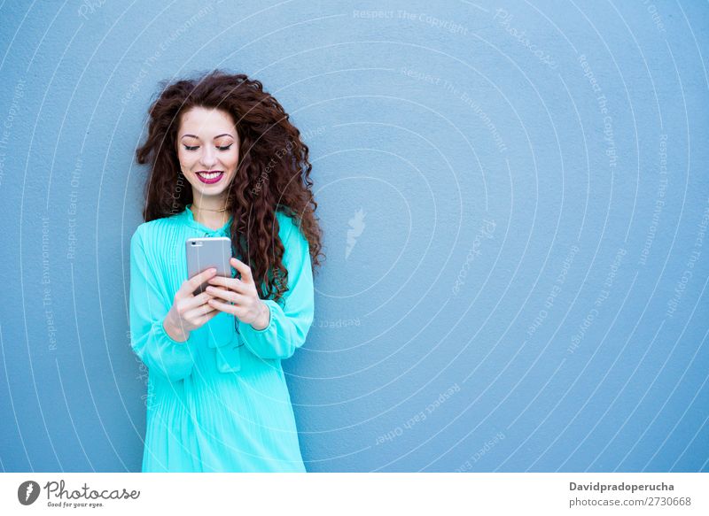 Glückliche junge Frau auf dem Handy an einer bunten Wand rothaarig Telefon Business Geschäftsfrau Technik & Technologie Mobile Lächeln Gesicht Beautyfotografie