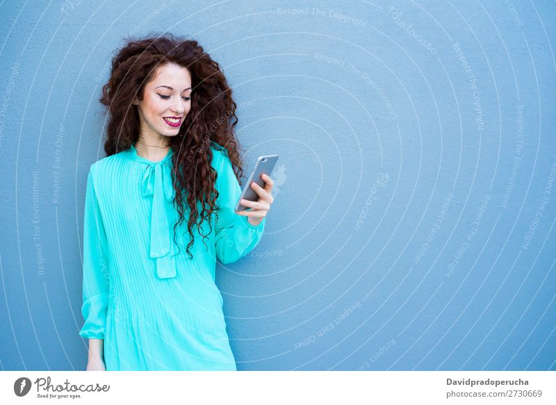 Glückliche junge Frau auf dem Handy an einer bunten Wand rothaarig Telefon Business Geschäftsfrau Technik & Technologie Mobile Lächeln Gesicht Beautyfotografie