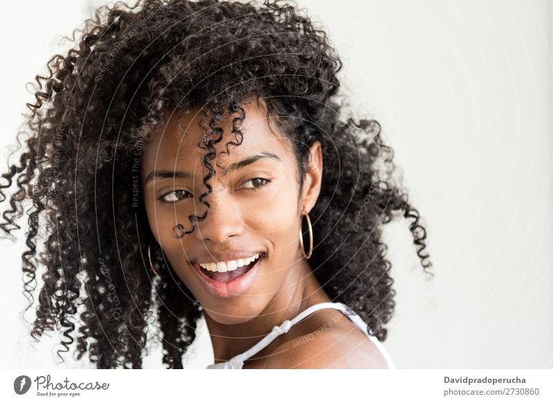 Porträt einer schönen jungen schwarzen Frau, die in die Kamera schaut. Nahaufnahme Lächeln niedlich hübsch Haut Afro-Look Beautyfotografie gut gemischt