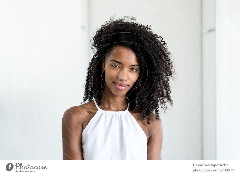 Porträt einer schönen jungen schwarzen Frau, die in die Kamera schaut. Nahaufnahme Lächeln niedlich hübsch Haut Afro-Look Beautyfotografie gut gemischt