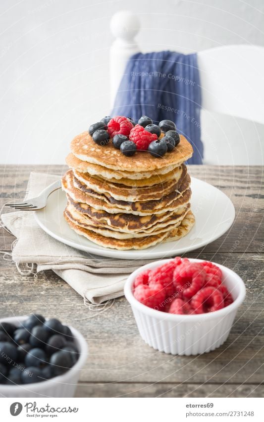 Pfannkuchen mit Himbeeren, Heidelbeeren und Honig süß Dessert Frühstück Blaubeeren Beeren blau rot backen Lebensmittel Gesunde Ernährung Foodfotografie Speise