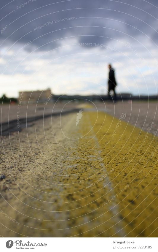 Der Mann an der Linie Hauptstadt Platz Flughafen Verkehrswege Straße Flugplatz Stein Beton stehen Stadt gelb grau Mensch laufen Grenzgänger Wolken