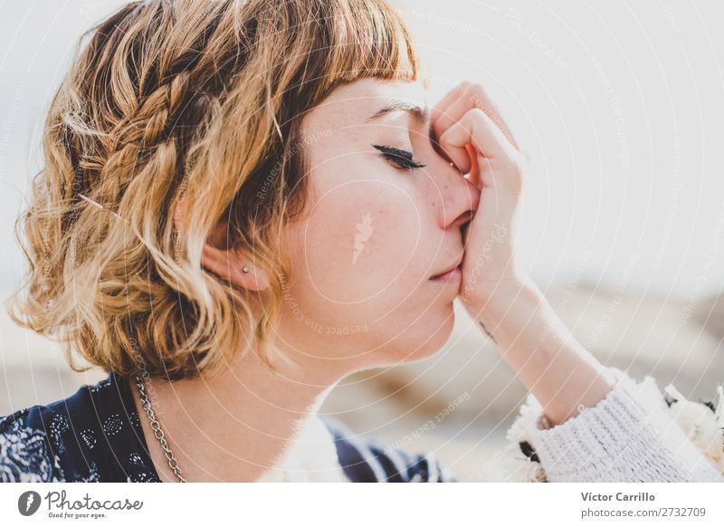 Eine blonde junge Frau an einem sonnigen Tag denkt und fühlt mit geschlossenen Augen Lifestyle elegant Stil Mensch feminin Junge Frau Jugendliche Erwachsene 1