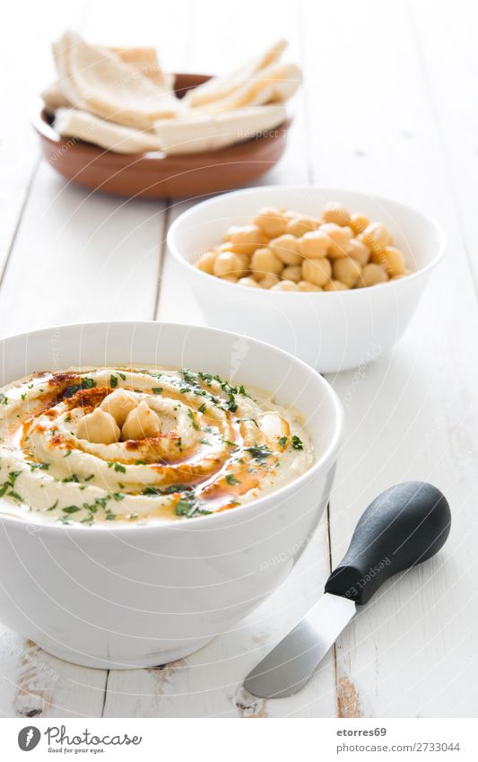 Hummus in der Schüssel und Pita-Brot auf Holztisch. Lebensmittel Gesunde Ernährung Foodfotografie Speise Kichererbsen Koriander Zitrone Olivenöl